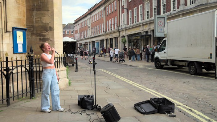 Straßenmusikerin singt auf einer Straße in York