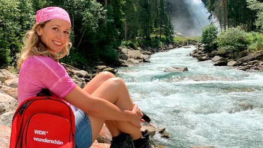 Tamina Kallert am Ufer der Krimmler Ache, im Hintergrund die Krimmler Wasserfälle