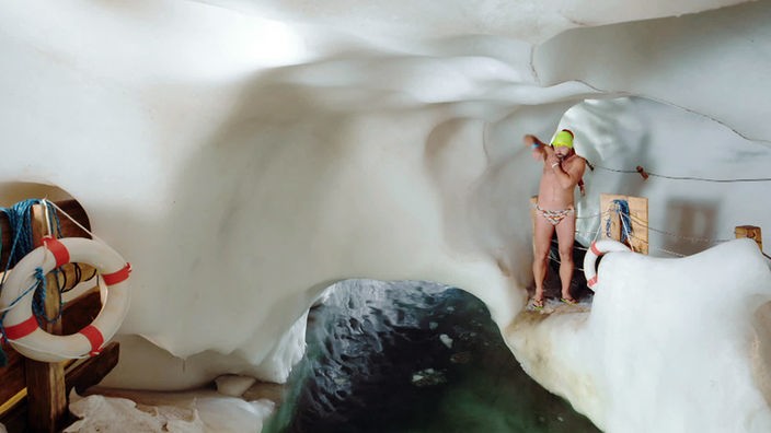 Eisschwimmer Josef Köberl steht nur mit Badehose bekleidet in der Eishöhle