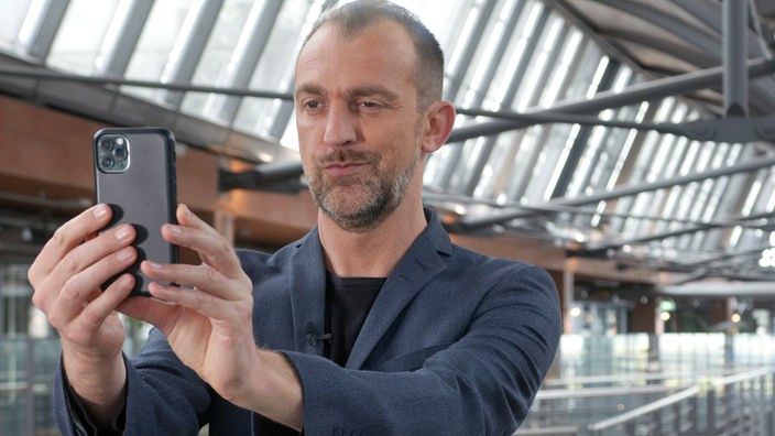 Moderator Michael Dietz in den WDR Arkaden bei einer Selfie-Aufnahme