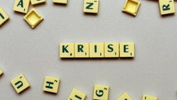 Der Schriftzug 'Krise' liegt zwischen anderen Scrabble-Buchstaben