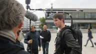 Timo Feldkamp mit Kameraausrüstung umgeben vom Kamerateam