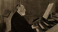 Camille Saint-Saens an einer Orgel, 1913