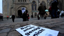 Ein Zettel mit der Aufschrift "Buße allein genügt nicht" vor einer Kirche