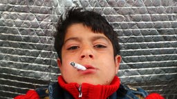 Syrischer Junge mit Zigarette im Mund