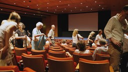 Ein Kinosaal füllt sich mit Besuchern