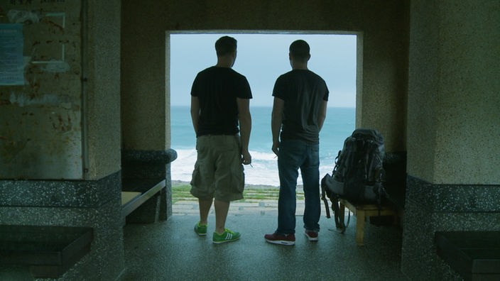 Felix und Max blicken durch eine Türöffnung aufs Meer in Taiwan