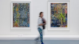 Eine Frau läuft an zwei Gerhard-Richter-Bildern in einer Düsseldorfer Ausstellung vorbei.