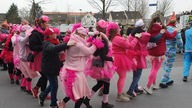 Frauen in Pink bilden schlange auf der Straße 
