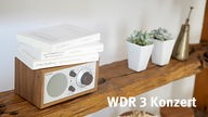 Ein Radiogerät auf einem Regalbrett, daneben der Schriftzug WDR 3 Konzert