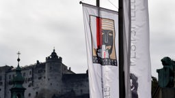Österreich, Salzburg: Die Fahne mit dem Logo der Salzburger Festspiele vor der Festung Hohensalzburg.