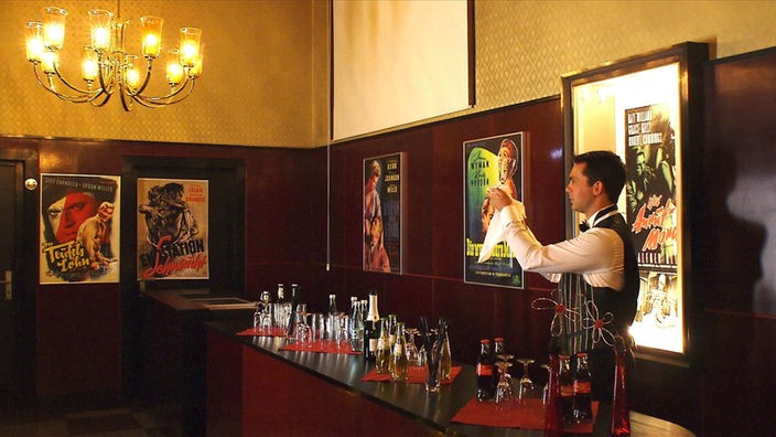 Barkeeper putzt ein Glas an der Bar im Heimhof-Theater Burbach