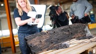 Archäologin Paula Kucharczyk scannt ein geborgenes Holzteil eines Schiffswracks mit einem Scanner.