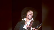 Gitarrist Jimi Hendrix (The Jimi Hendrix Experience) raucht eine Zigarette während eines Konzerts -  1969