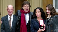 Mick Jagger mit Vater und Töchtern bei der Zeremonie zu seinem Ritterschlag vor dem Buckingham Palace 2003