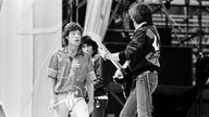 Mick Jagger und Keith Richards werfen sich bei einem Auftritt im Jahr 1982 in Köln Grimassen zu
