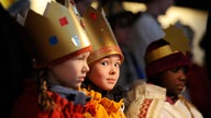 Drei Kinder sind als Sternsinger verkleidet