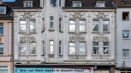 Verzierte Fassade in Gelsenkirchen-Ückendorf, am Eingang des Hauses steht "Wie viel Wert steckt in diesem Haus?"