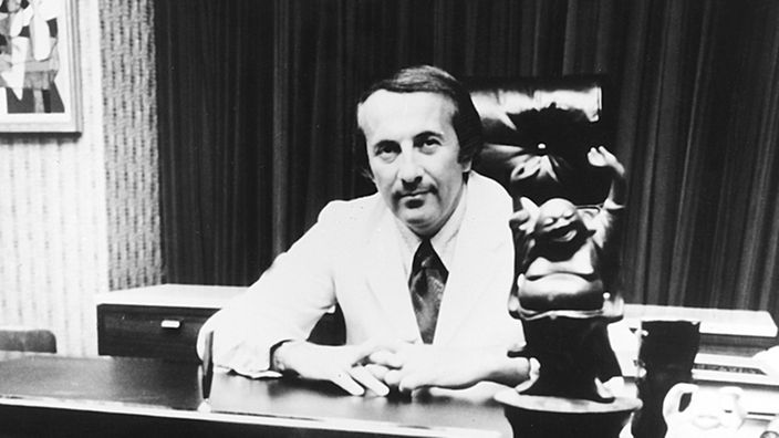 Robert Atkins sitzend am Schreibtisch, ca. 1973
