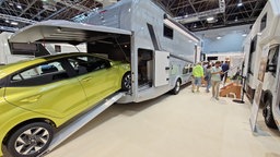 Ein luxuriöser Caravan mit einem Sportwagen