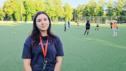 Carolina Graef Alarcón steht auf dem Fußballplatz.