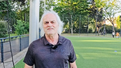 Jugendleiter Marcel Moser steht auf dem Fußballplatz.