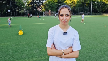 Selin Dikbasan steht auf dem Fußballfeld und schaut in die Kamera.