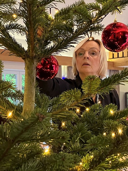 Gudrun Högemann schmückt einen Weihnachtsbaum