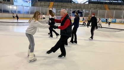 Dieter Büllesbach trainiert Eislaufen mit einem Mädchen
