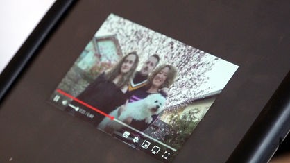 Auf einem Tablet ist ein Standbild der Videobotschaft von Alexander Oberst und seiner Familie zu sehen.