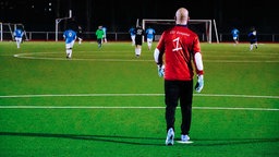 Ein Mann in einem Fußballtor auf dem Spielfeld