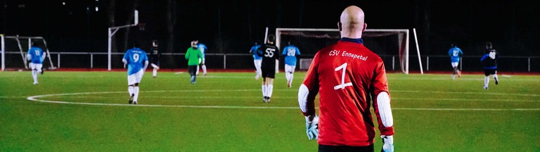 Ein Mann in einem Fußballtor auf dem Spielfeld