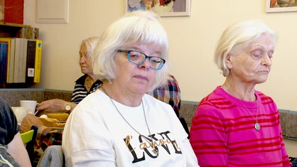 Eine ältere Frau mit weißen Haaren und einer Brille