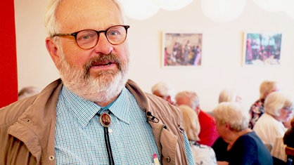 Einen Mann mit Brille und grauem Bart