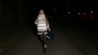 Ina Hackstein sucht im Dunkeln mit einer Taschenlampe nach Kröten
