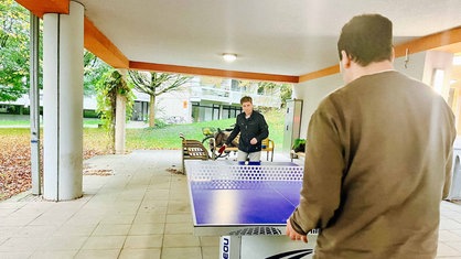 Zwei Männer spielen Tischtennis.