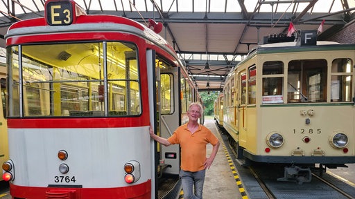 Michael Mertner zwischen zwei historischen Straßenbahnen