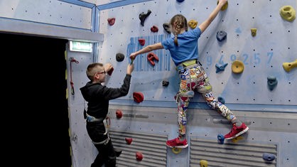 Kinder klettern an der Wand
