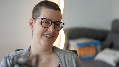 Britta Tenberge aus Lüdinghausen sitzt in ihrem Wohnzimmer vor einem Mikrofon.