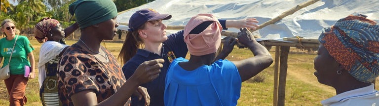 Sarah Easter befestigt mt mehreren schwarzen Frauen eine Dachplane