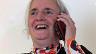 Therapeutin Gudrun Haep lacht mit dem Handy am Ohr
