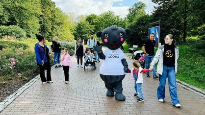 Das Maskottchen Loona wird von mehrern Kindern und Eltern begleitet.