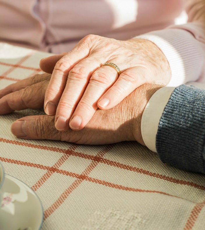 Ein Senioren-Pärchen hält sich an den Händen
