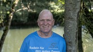 Oli Trelenberg aus Hagen trägt ein blaues T-Shirt mit der Aufschrift "Radeln für den guten Zweck"