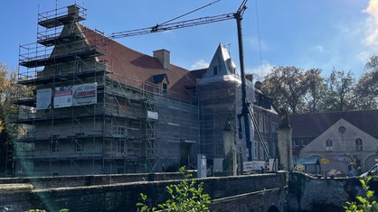 Das Schloss Senden wird renoviert. Man sieht das Schloss und ein Baugerüst. 