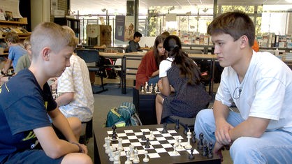 Zwei Schüler spielen in einem Klassenzimmer Schach
