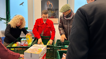 Michael Draeger und sein Sohn Karim sortieren mit Cornelia Gerber die Sachspenden