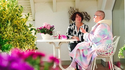 Petra Heinse und Stefanie Kampschulze sitzen gemeinsam auf dem Balkon.