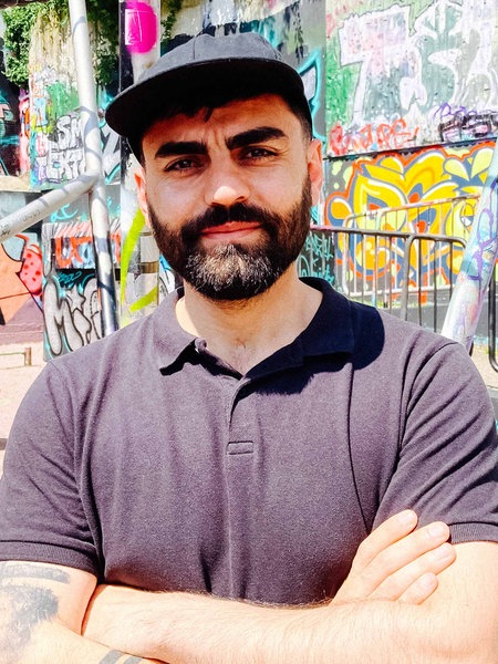 Hussein Shahin vor einem Hintergrund mit Graffitti.