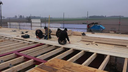 Freiwillige auf einer Baustelle verlegen Holzbohlen